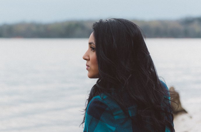 Angst- und Panikstörungen - Frau mit schwarzen Haaren, die aufs Wasser guckt