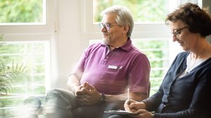 Aufnahme-Gespräch Ein Mann und eine Frau sitzen nebeneinander, die Frau schreibt etwas auf einen Zettel.