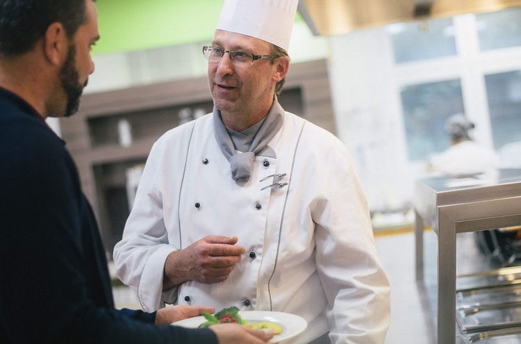 Ernährung Mann unterhält sich mit Küchenchef und freut sich auf sein Essen.