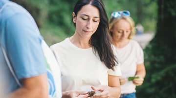 Depressionen bei Ärzten - Frau mit Tannenzapfen in der Hand