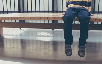 „Das ist dramatisch, denn es löst Schuldgefühle bei den Kindern aus“ Artikel Kinder: Junge der auf einer Bank sitzt