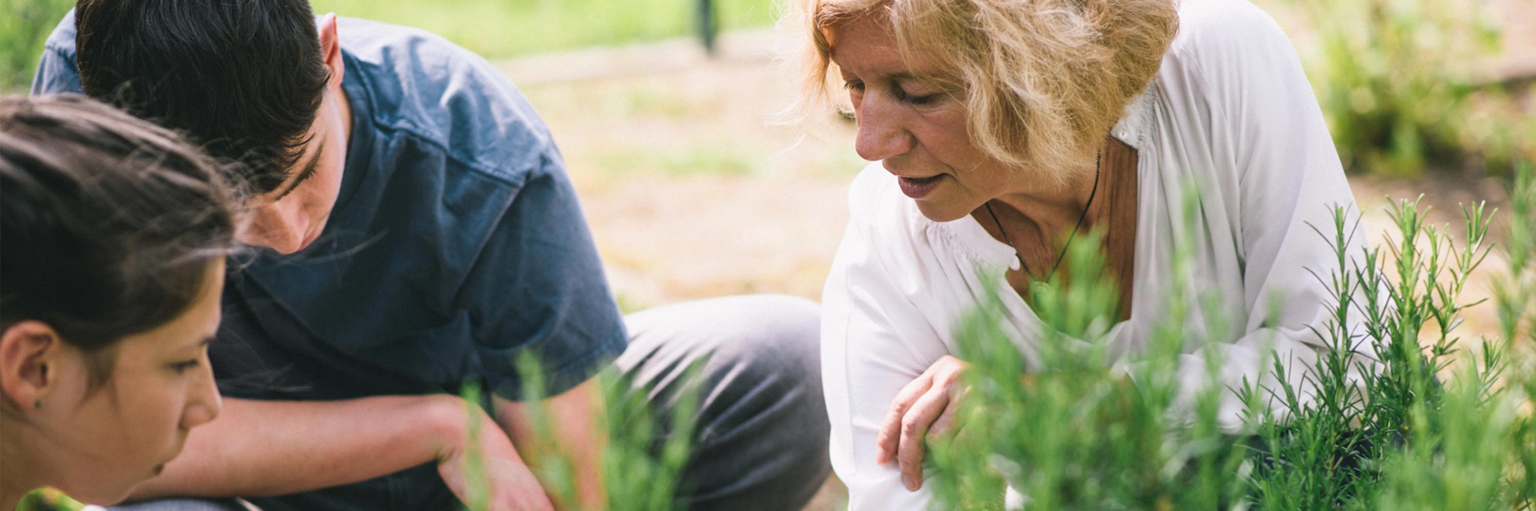 Therapeutin erklärt von Essstörungen betroffenen Jugendlichen unterschiedliche Pflanzen im klinikeigenen Kräutergarten