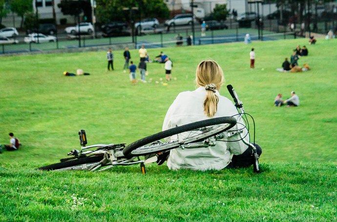Chronische Rückenschmerzen, die seelische Schmerzen bereiten Artikel Rückenschmerzen: Frau mit Fahrrad auf einer Wiese