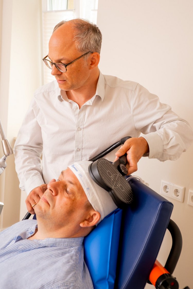 Chefarzt wendet rtMS bei Patient an