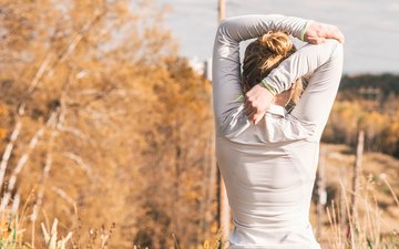 Was macht glücklich? Artikel Glücklichkeit Frau vor Bäumen