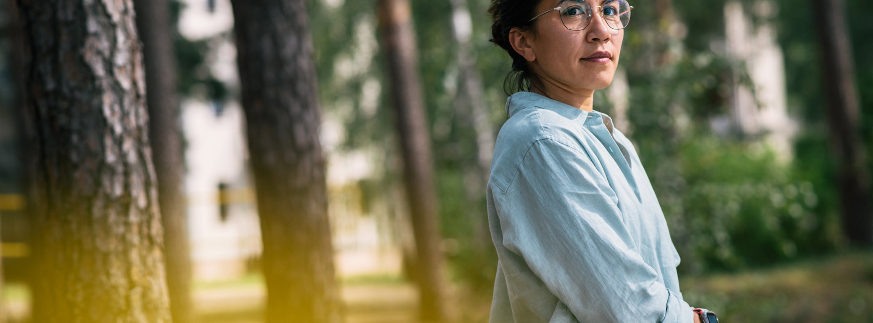 Angststörung erfolgreich therapieren Eine Frau im Profil,  im Hintergrund Bäume: Therapie der Angststörung in heilsamer Umgebung