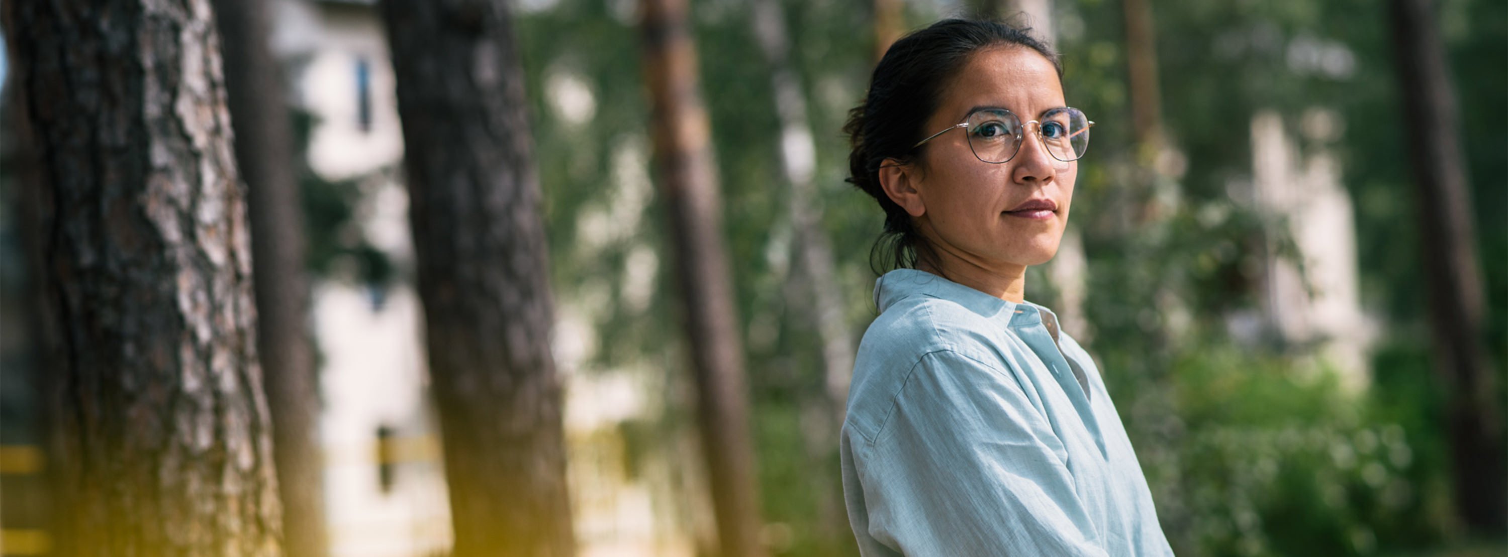 Eine Frau im Profil,  im Hintergrund Bäume: Therapie der Angststörung in heilsamer Umgebung