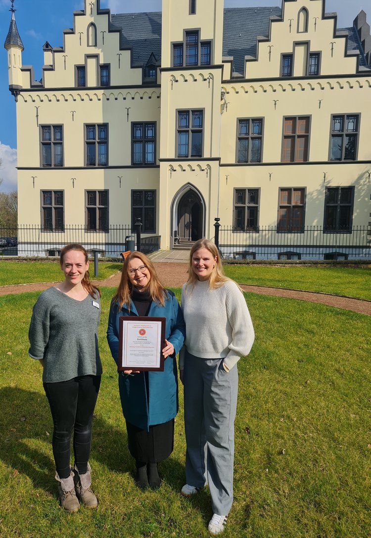 Sonja Alefs, Dr. med. Ewa Cionek-Szpak und Sophia Jordan mit Urkunde vor dem Wasserschlösschen