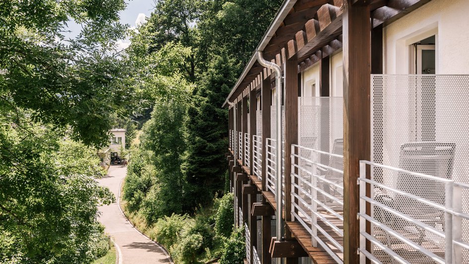 Klinik-Umgebung Die Fassade der Klinik, die direkt an Bäume und Sträucher grenzt.