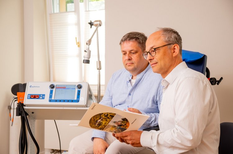 Chefarzt klärt Patient im Gespräch über rTMS auf