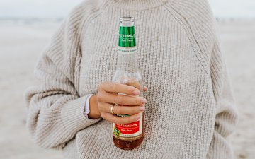 Drunkorexie: Gefährlicher Trend Artikel Drunkorexie: Frau mit Somersby in der Hand am Strand
