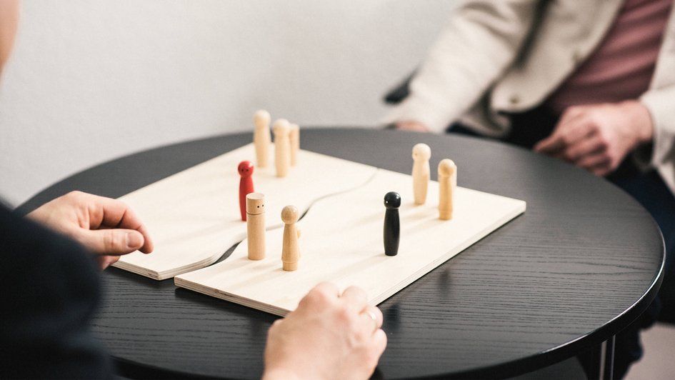 Zwei Personen mit einem Brett und Figuren auf einem Tisch