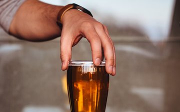 Alkoholismus - Bierglas und Hand