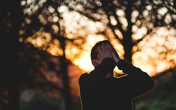 Borderline Persönlichkeitsstörung: Symptome, Ursachen & Therapie Borderline - Mann mit Händen vor dem Gesicht mit Wald im Hintergrund