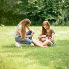 Zwei junge Frauen auf einer Wiese mit einem Hasen