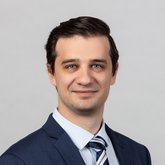 Portraitfoto Dr. Maxim Kuzin im dunkelblauen Anzug