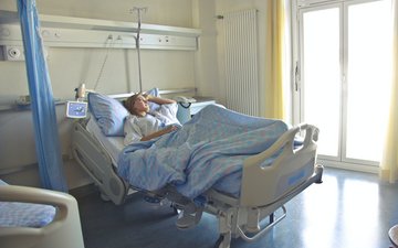 Die Würde jedes einzelnen Menschen Artikel Covid: Frau im Krankenhausbett