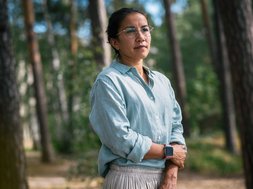 Resilienz - Frau mit blauem Oberteil und Brille im Wald