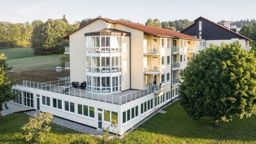 Fachklinik Rhein-Jura Die Fachklinik Rhein-Jura ist in der Totalen zu sehen. Im Hintergrund Wiesen und Bäume.