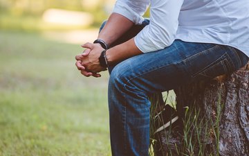 Die schönsten Wochen des Jahres? Teil 3: Achtsam durch die Ferien Artikel Burnout Mann sitzt auf Baumstamm