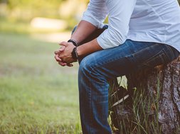 Artikel Therapiegarten Rhein-Jura: Mann sitzt auf einem Baumstamm