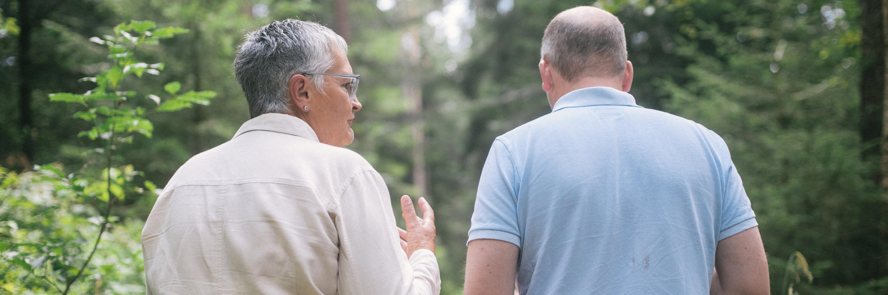 Therapiegespräch in erholsamer Umgebung: Therapeut und Patient widmen sich der Therapie von Zwangsstörungen umgeben von Bäumen