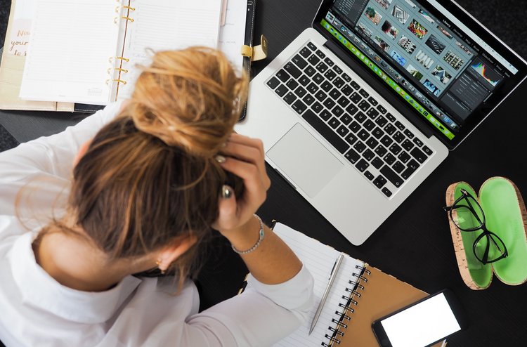Stress am Arbeitsplatz Frau sitzt gestresst am Arbeitsplatz