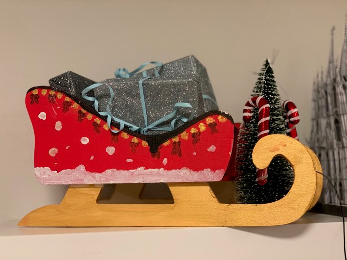 fesetlich geschmückter kleiner Weihnachtsschlitten mit Geschenken