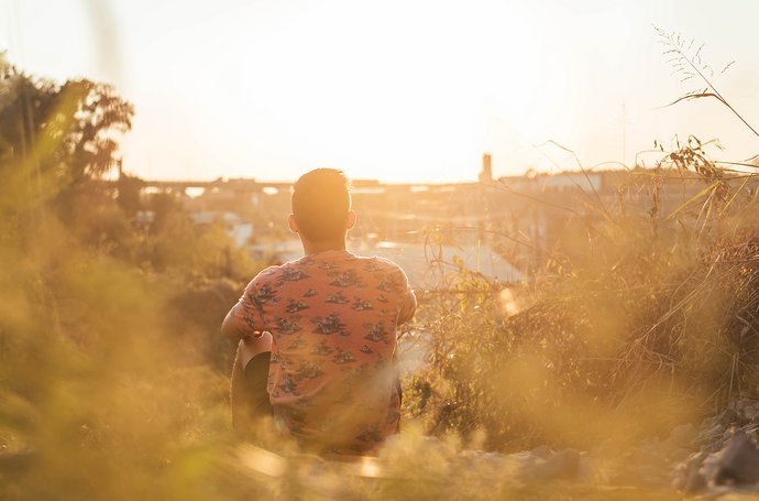 Trauma - Mann der in einem Feld sitzt