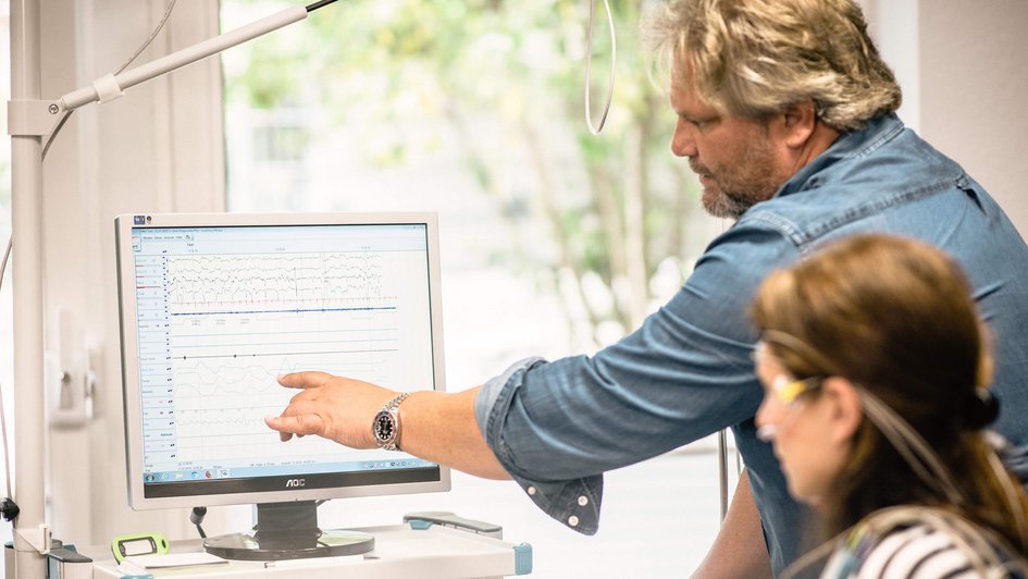 Mann zeigt auf einen Computer Bildschirm