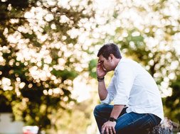 Frühjahrsmüdigkeit & Frühjahrsdepression: Symptome, Unterschiede & Auswege Artikel Frühjahrsmüdigkeit Mann mit der Hand vor dem Gesicht