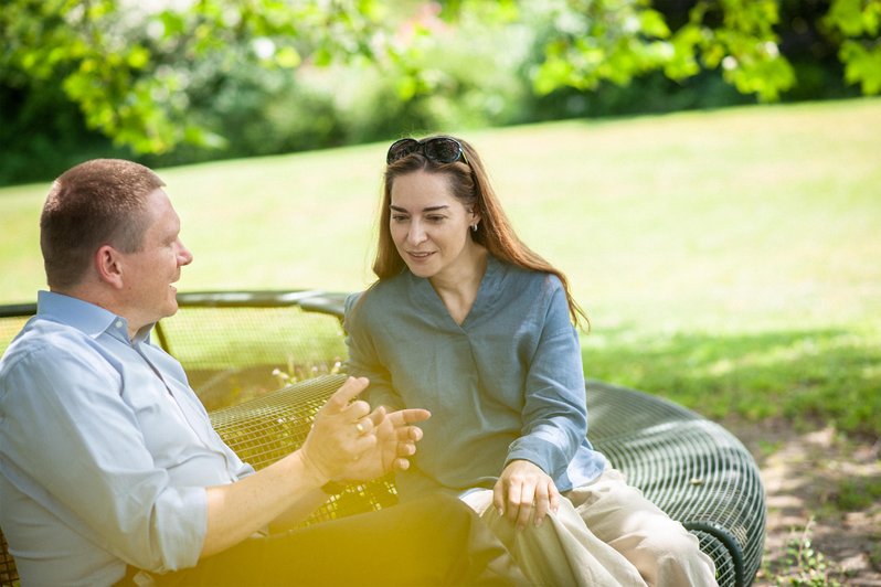 Artikel Migräne: Patientin und Therapeut auf einer Bank in der Natur