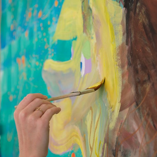 gelbe Farbe wird mit Pinsel auf Bild gebracht