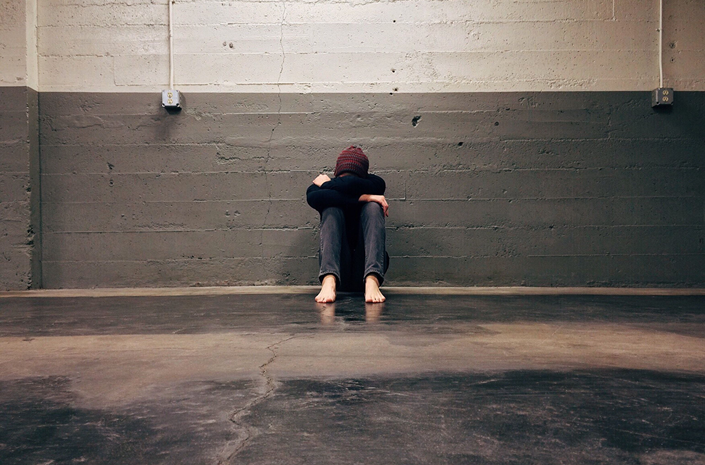 Person sitztz in einer Garage auf den Boden