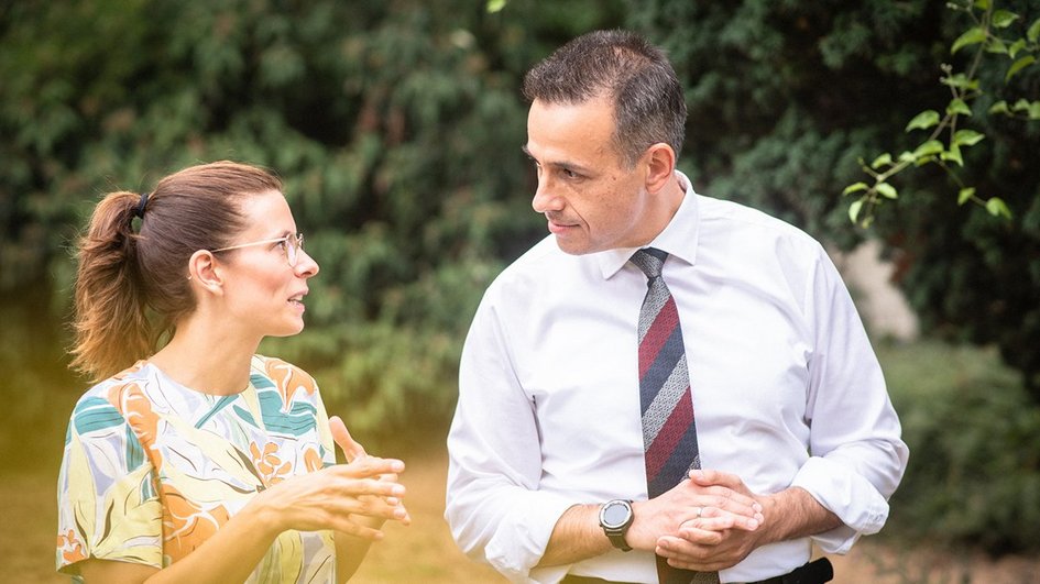 Ein Mann und eine Frau reden bei einem Spaziergang in der Natur miteinander